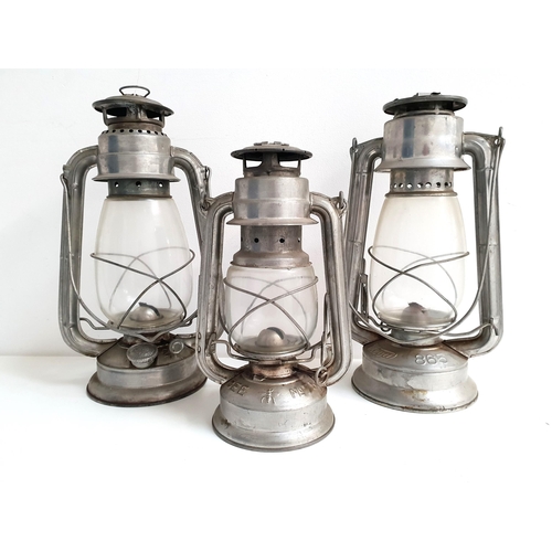 211 - THREE VINTAGE METAL OIL LAMPS
comprising an Ever Bright 202, 31.5cm high, Meva 865, 31.5cm high, and... 