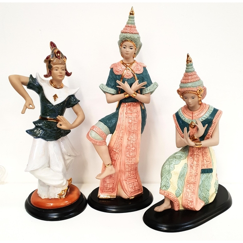 180 - THREE POTTERY SIAMESE DANCERS
in traditional dress, raised on wooden plinths, 52cm, 44cm and 40.5cm ... 