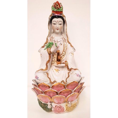 184 - PORCELAIN FIGURINE GUANYIN
seated with crossed legs on a lotus leaf base, holding a gilt urn and a b... 