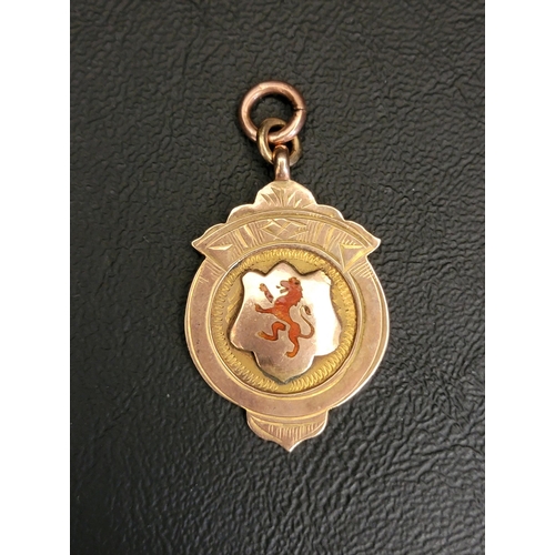 99 - NINE CARAT GOLD SPORTING MEDAL FOB
the front with red enamel lion rampant, the reverse engraved 'T.A... 