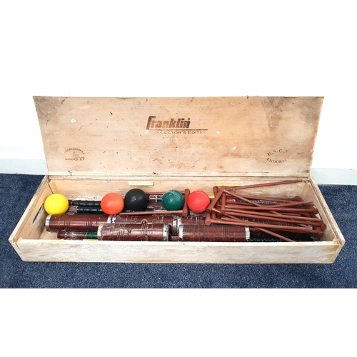 244 - FRANKLIN CROQUET SET
in a wooden case with five coloured balls, six mallets, hoops and a centre peg