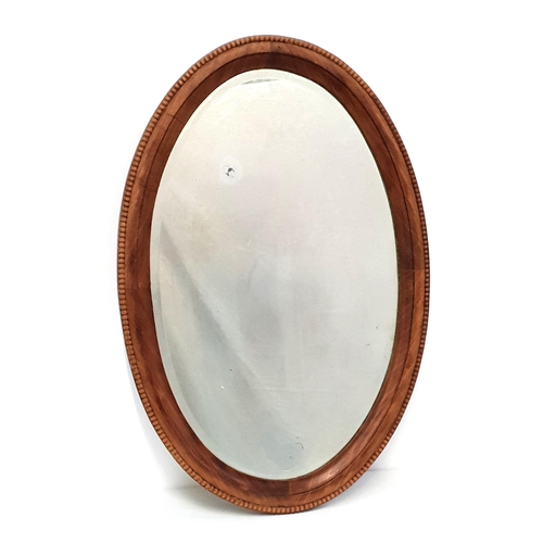 439 - TEAK FRAME WALL MIRROR
with an oval frame and bevelled plate, 84.5cm x 56.5cm