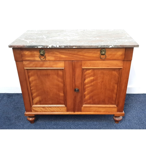 354 - CONTINENTAL SATINWOOD SIDE CABINET
with a rectangular grey marble top above a frieze drawer with lio... 