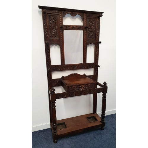 375 - CARVED OAK HALL STAND
with a carved panel back and a central bevelled mirror surrounded by eight tur... 