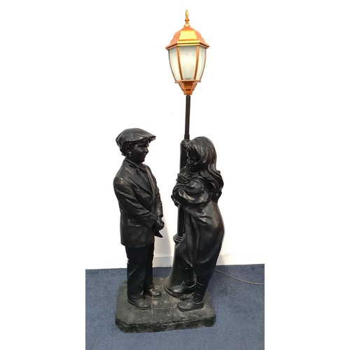 434 - LARGE NOVELTY RESIN LAMP
depicting a well dressed young boy and girl talking by a street lamp, 171cm... 