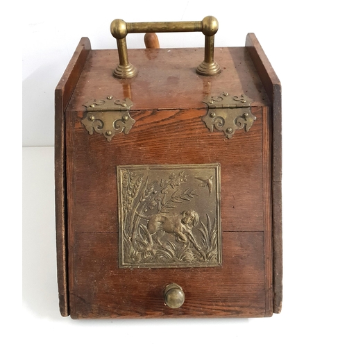 319 - OAK SHAPED COAL SCUTTLE
with a brass carry handle and decorative hinges, the sloping lid with an emb... 