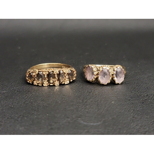 113 - TWO GEM SET NINE CARAT GOLD RINGS
comprising a graduated smoky topaz five stone ring and pink topaz ... 