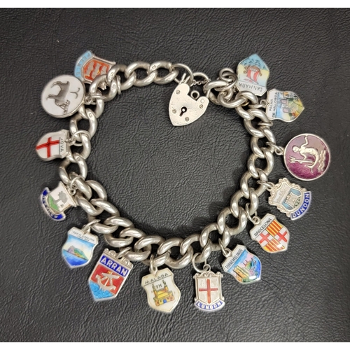 SILVER CURB LINK CHARM BRACELET
with a selection of enamel decorated silver souvenir charms, including Barcelona, Malaga, Glasgow and Dunoon, with padlock clasp, total weight approximately 60 grams