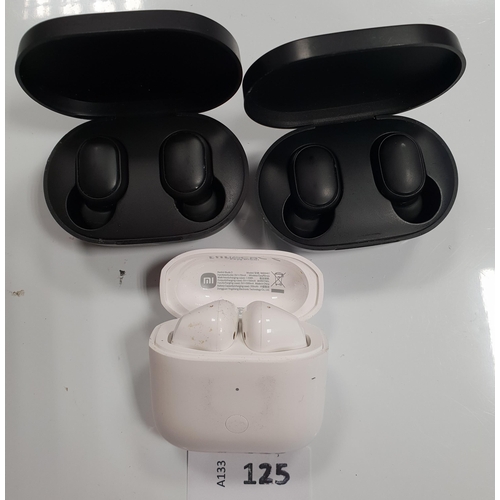 125 - THREE PAIRS OF MI EARBUDS IN CHARGING CASES