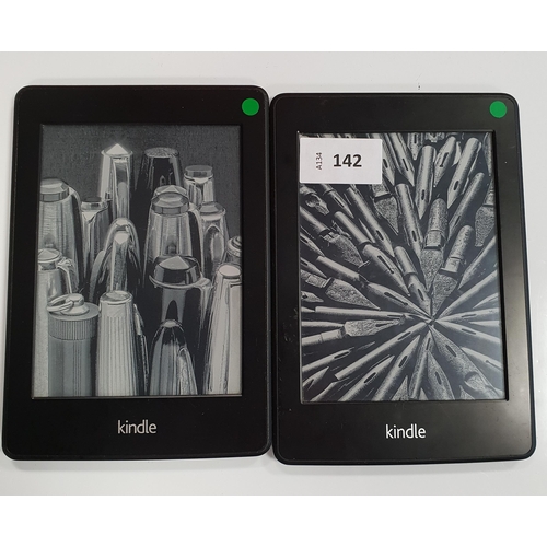 142 - TWO AMAZON KINDLE PAPERWHITE E-READERS
comprising a Paperwhite 2 serial number 90D4 2201 4047 080X a... 