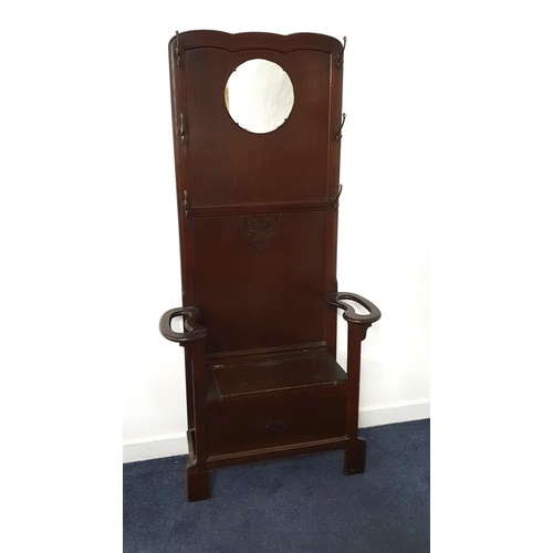 309 - 1930s OAK HALL STAND
with a circular mirror and an arrangement of six coat hooks above a lift up sea... 