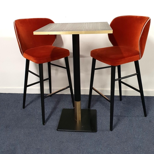 BLACK ASH EFFECT HIGH BISTRO TABLE AND TWO BAR STOOLS
the table with a square top and brass effect edge on a turned metal column with brass collar and black metal weighted base, 114cm high, the top 70cm x 70cm; the high back stools in orange velour with padded seats