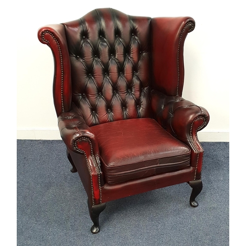 290 - CHESTERFIELD WING BACK ARMCHAIR
in ox blood leather with a button back and scroll arms with decorati... 