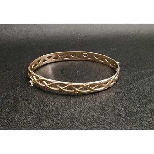 NINE CARAT GOLD BANGLE 
of pierced and entwined design, approximately 12 grams