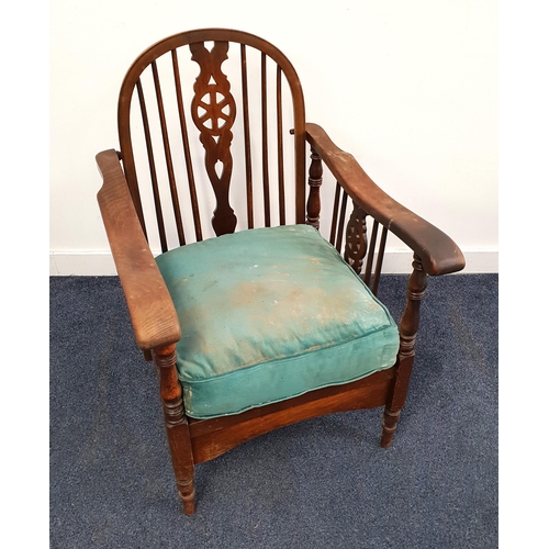 1930's OAK WHEELBACK ARMCHAIR
with a folding arch back above shaped arms and a loose seat cushion, standing on turned supports
