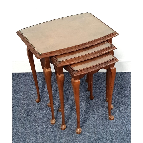 WALNUT NEST OF TABLES
with glass tops, standing on cabriole supports, 52.5cm high