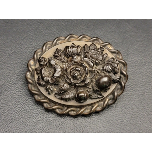 105 - CARVED JET BROOCH
the oval brooch with carved flowers within a rope twist border, 4.8cm wide