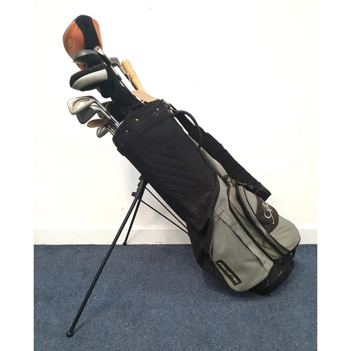 SET OF GOLF CLUBS
with five drivers, two sand wedges, pitching wedge, 3, 4, 5, 6, 7, 8, and 9 iron, in a black John Letters bag with a folding stand, tees and an umbrella