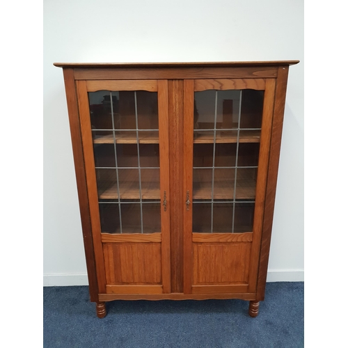 394 - OAK BOOKCASE
the rectangular top above a pair of three quarter leaded glass doors with panels below,... 