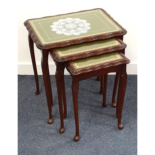 458 - MAHOGANY NEST OF TABLES
with inset green leather glass covered tops, standing on cabriole supports, ... 