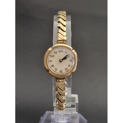 144 - LADIES NINE CARAT GOLD CASED WRISTWATCH
the circular dial with Arabic numerals, on expanding bracele... 