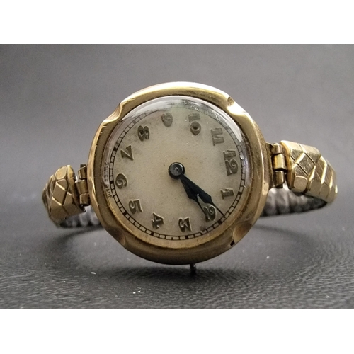 144 - LADIES NINE CARAT GOLD CASED WRISTWATCH
the circular dial with Arabic numerals, on expanding bracele... 