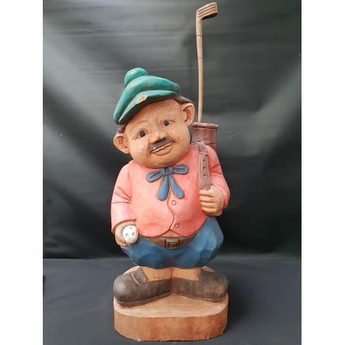 268 - CARVED TEAK FIGURE OF A GOLFER
with his golf bag over his shoulder and carrying a golf ball, with on... 