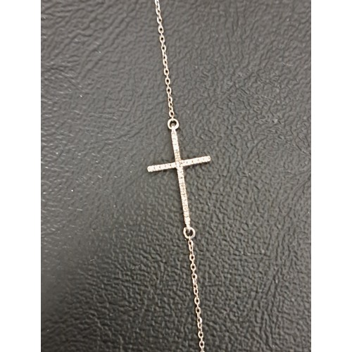 62 - DIAMOND SET CROSS PENDANT
in nine carat white gold and on attached chain, total weight approximately... 