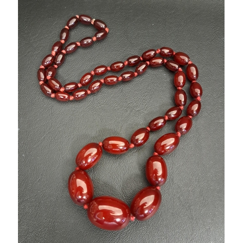 74 - GRADUATED CHERRY AMBER BEAD NECKLACE
individually knotted, the largest bead approximately 2.9cm long... 