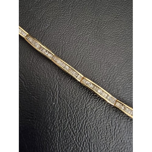 72 - DIAMOND LINE BRACELET
in ten carat gold, the channel set round and baguette cut diamonds totalling a... 