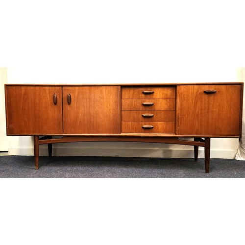 433 - G PLAN TEAK SIDEBOARD
with four drawers, a pull down door and a pair of cupboard doors, standing on ...