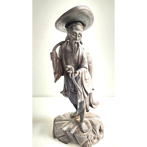 EARLY 20th CENTURY CHINESE CARVED WOOD FIGURE
depicting a fisherman with a fish being carried on his back and holding a pipe, 35.5cm high