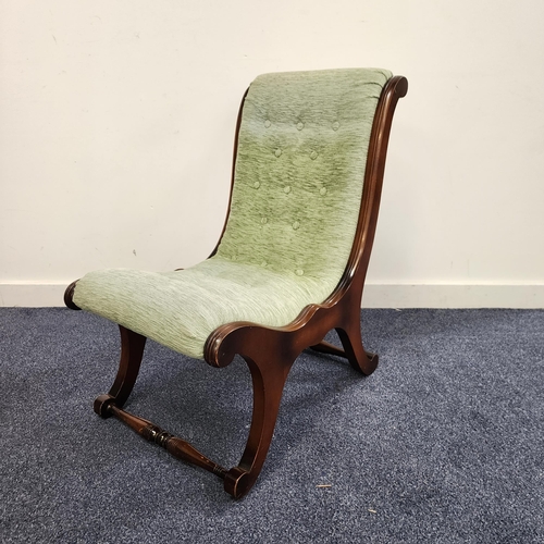 MAHOGANY SLIPPER NURSING CHAIR
with a button back and seat on shaped supports united by a stretcher