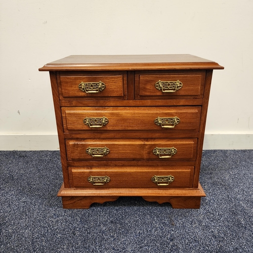 SMALL TEAK CHEST OD DRAWERS
with a moulded top above two short panelled drawers and three long panelled drawers, standing on bracket feet, 49.5cm x 50cm x 31cm