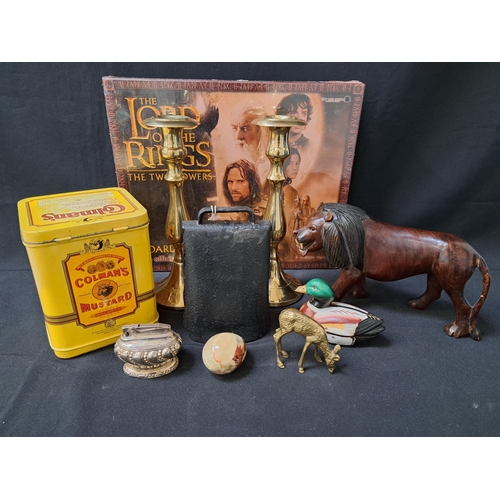 MIXED LOT OF COLLECTABLES
including a new and unused The Lord Of The Rings, The Two Towers board game, vintage metal cow bell, Ronson Crown table lighter, onyx egg, duck jewellery box, brass deer, carved lion, pair of brass candlesticks and a Colmans Mustard tin