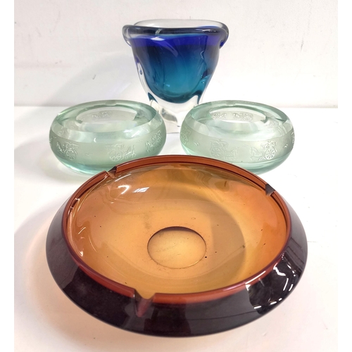 BOHEMIAN GLASS SHAPED BOWL
in blue and green encased in clear glass, on an irregular foot, 16cm high, two pale green glass ashtrays decorated with horse and carts, 14cm diameter, and an amber glass circular ashtray, 20cm diameter (4)