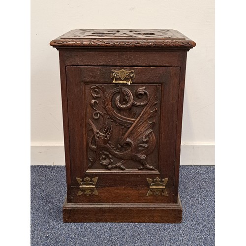 EDWARDIAN CARVED OAK COAL PURDONIUM
the lid carved with a 'WB' above a fall door decorated with a dragon, with an internal metal liner, standing on a plinth base, 55.5cm x 37.5cm x 33.5cm