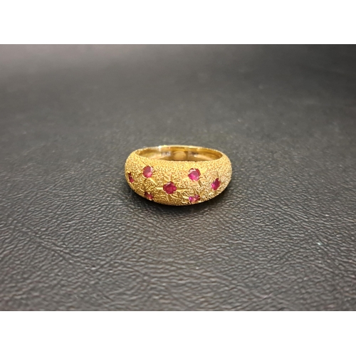 RUBY SET BOMBE STYLE GYPSY RING
with seven flush set rubies against a textured setting and shank, in unmarked high carat gold (tests as eighteen carat), ring size N-O and approximately 5.3 grams
