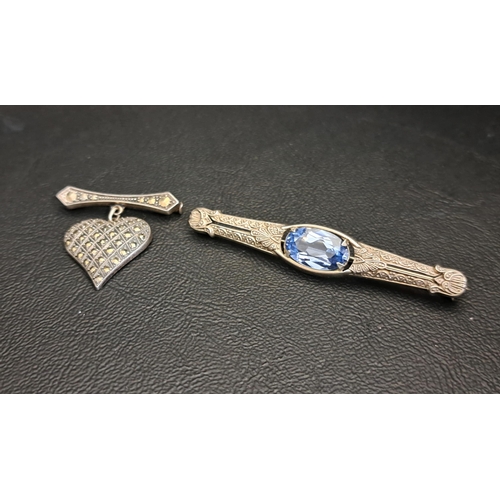 TWO SILVER BROCHES
one a bar brooch with central oval cut blue topaz and relief decoration overall, marked 835, 6cm long; the other with heart drop and set with marcasite, marked 935, both with boxes