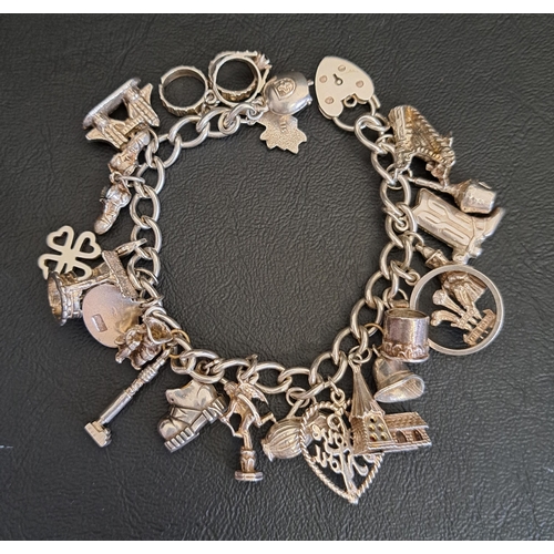 SILVER CHARM BRACELET
with a good selection of charms, including a shoe, a well and Tower Bridge, total weight approximately 66.7 grams