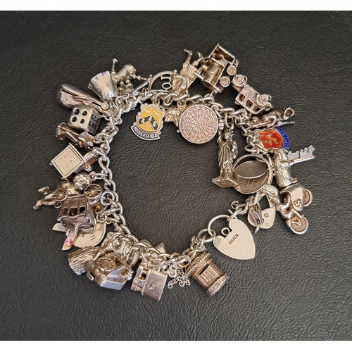 SILVER CHARM BRACELET
with a good selection of charms, including articulated train, carriage and dart board, total weight approximately 87 grams