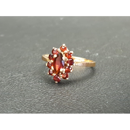 GARNET CLUSTER RING
the central marquise gemstone in surround of ten round cut garnets, on nine carat gold shank, ring size O-P and approximately 2.3 grams