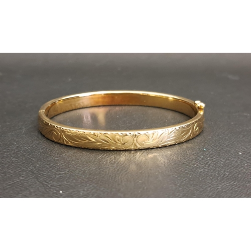 NINE CARAT GOLD BANGLE
with engraved scroll decoration, approximately 12.3 grams