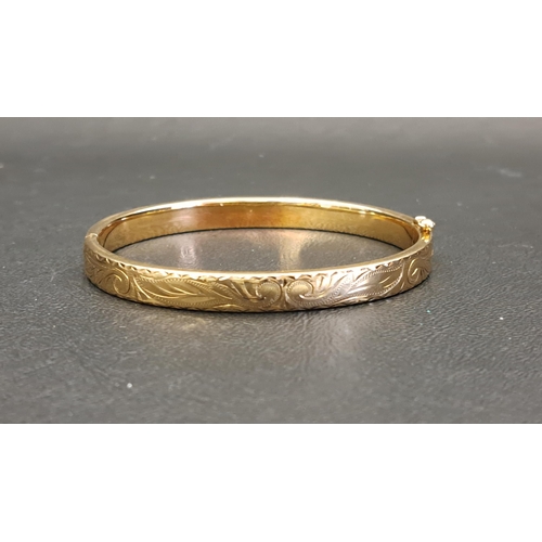 80 - NINE CARAT GOLD BANGLE
with engraved scroll decoration, approximately 12.3 grams