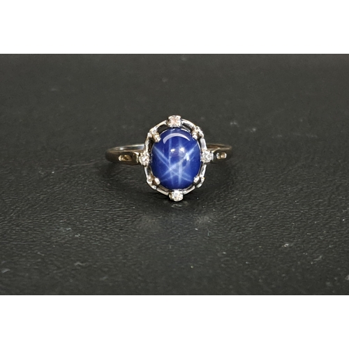 STAR SAPPHIRE AND DIAMOND RING
the central cabochon sapphire approximately 9.7mm x 7.6mm, the surround with four diamonds, on fourteen carat white gold shank, ring size R-S and approximately 3.7 grams