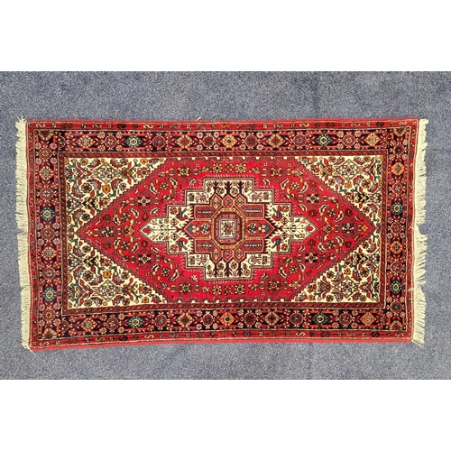 445 - GHOLTOGH RUG
with a red ground and geometric decoration with birds and flower heads, 137cm x 76cm