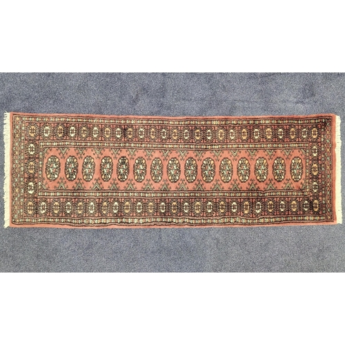 452 - BOKHARA RUNNER
with a terracotta ground and lozenge motifs, 184cm x 63cm