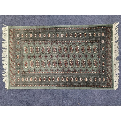 453 - BOKHARA RUG
with a green ground and lozenge motifs, 157cm x 93cm