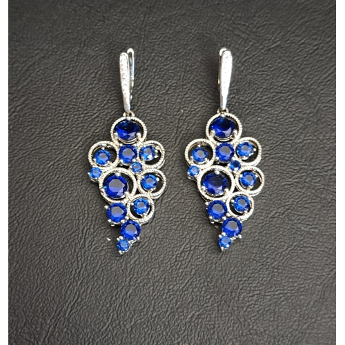 108 - TWO ORNATE SILVER PENDANTS
both set with diamonds to the suspension loop and faceted blue glass to t... 