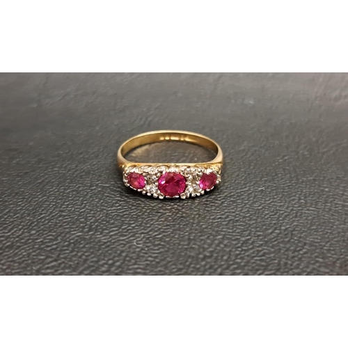 102 - RUBY AND CLEAR GEM SET RING
the three graduated round cut rubies separated by small clear gemstones,... 